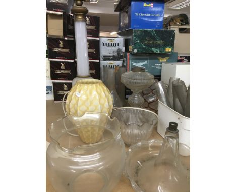 A collection of oil lamp parts funnels and shades a glass dome and a oil lamp base .