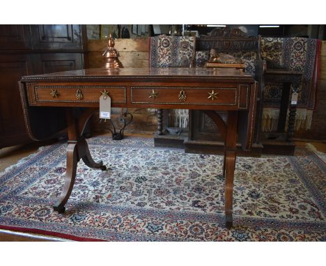 A good Regency gilt metal strung rosewood sofa table, the drop end rectangular top with rounded corners, over two frieze draw