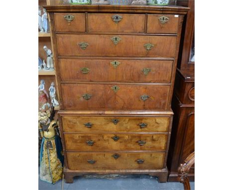 An 18th century cross-banded walnut chest on chest having three short over three long graduated drawers flanked by canted mou
