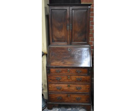 A diminutive George III mahogany bureau cabinet, the pair of fielded panel cabinet doors enclosing five drawers over a fitted