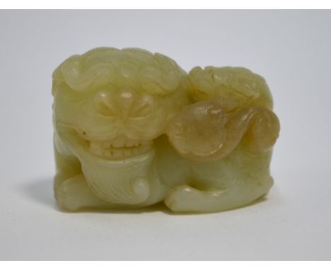 A small green jade figure, carved as a recumbent Buddhist Lion with a pup on its back, 4.5 cm long, post Qing DynastyThe ston