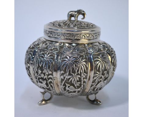 An Indian white metal melon-shaped sugar basin and cover with elephant finial, the lobed body richly engraved and chased with