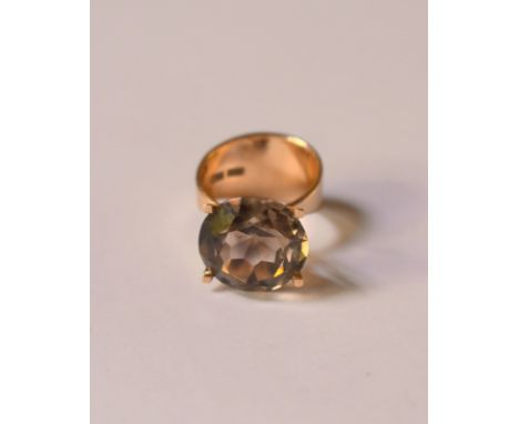 A large single stone circular smokey quartz ring in high claw setting, yellow metal setting stamped 585, size K, the smokey q