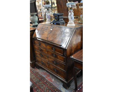 An 18th century walnut bureau, the fall enclosing a fitted interior over four long graduated drawers, raised on shaped bracke