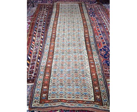 Early 20th century Persian Kurdish runner, the camel ground central reserve with repeating bands of floral motif within palme