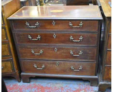 A George III cross-banded mahogany chest of four long graduated drawers with cast ormolu fittings, raised on shaped bracket f