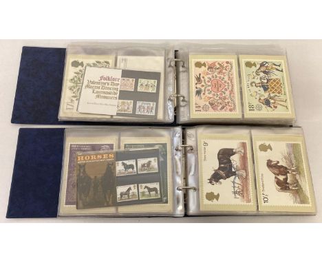 2 blue British Post Office Picture Card albums containing a total of 38 sets of mint collectors stamps and corresponding post