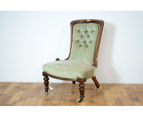 A Victorian walnut framed nursing chair, the carved frame with scrolled terminals, button backrest upholstered in light green