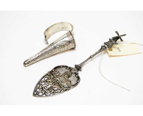 A Dutch cake slice, with windmill scene and rotating windmill finial, stamped 'Luvo', 23cms high; together with a white metal