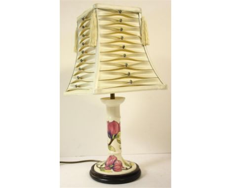 A Moorcroft pink magnolia pattern lamp base; with dark wood base.  20 cm high.