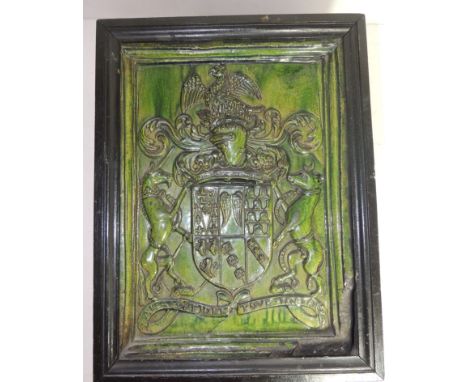 A 19th Century glazed pottery stand (?) the heavy terracotta piece moulded with a coat of arms to the top within moulded fram