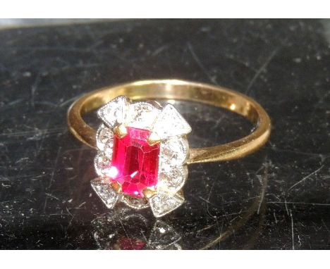 A ruby and diamond ring, the central square cut ruby with diamond surround and in unmarked gold mount