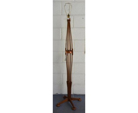 A 1950's teak and copper standard lamp; raised on four supports and bun feet, with four teak vertical ribs.  152 cm high.
