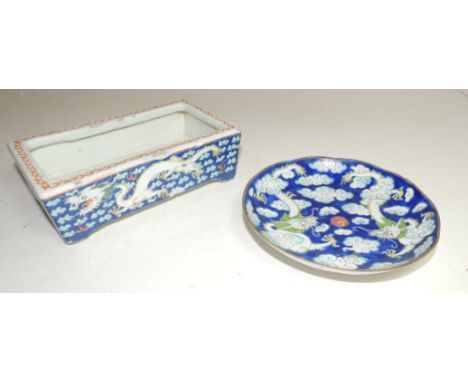 A small Chinese glazed pottery trough with dragon decoration, 16cms wide together with a small glazed porcelain saucer painte