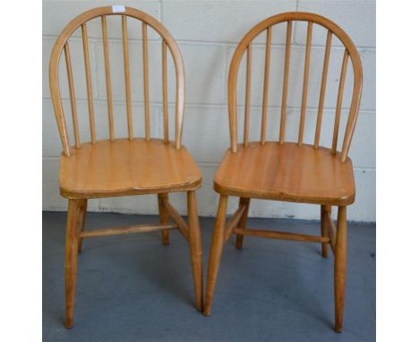 Two Ercol original Windsor dining chairs; designed by Lucian Ercolani, in elm and beech.