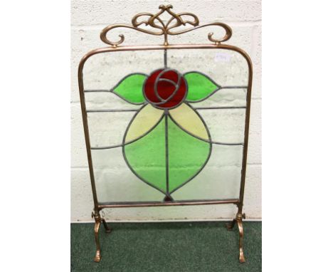 An Arts & Crafts copper fire screen; with stained glass panels forming a stylised rose.  44 cm wide, 74 cm high.