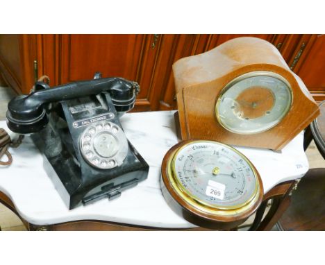 A black Bakelite telephone, chiming mantle clock, and a wall barometer