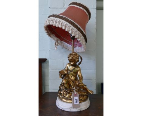 A gilt cherub table lamp with shade