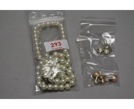A simulated pearl necklace with two bracelets and a pair of earrings.