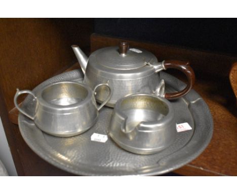 A vintage hammered pewter tea pot, tray, sugar basin and jug.