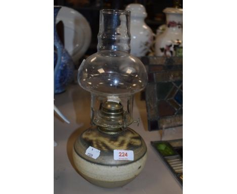 A vintage unmarked studio pottery oil lamp with glass chimney.