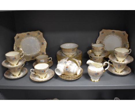 A vintage Plant Tuscan part tea service in a cream and gilt ground with floral details.