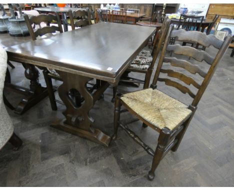 An Ercol refectory dark oak extending dining table and four ladder backed chairs 