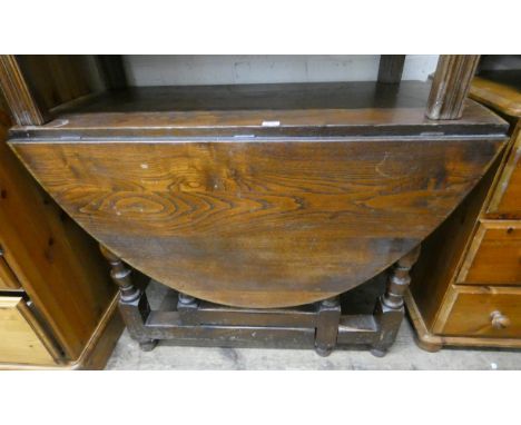 A 3'6 dark oak gate legged dining table on bulbous legs 