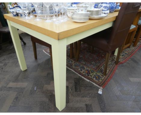 A modern light oak rectangular dining table with cream legs