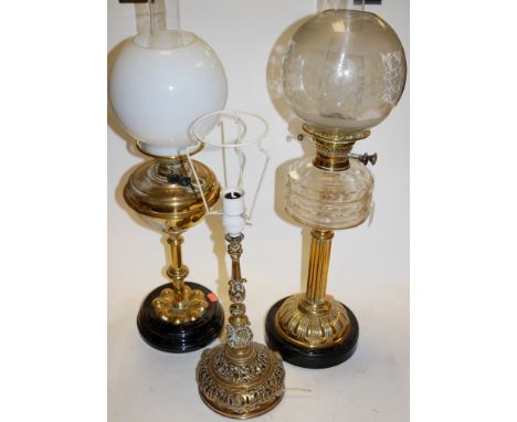 A Victorian oil lamp, having globular glass shade, clear glass reservoir, on a brass pedestal base; together with two other V