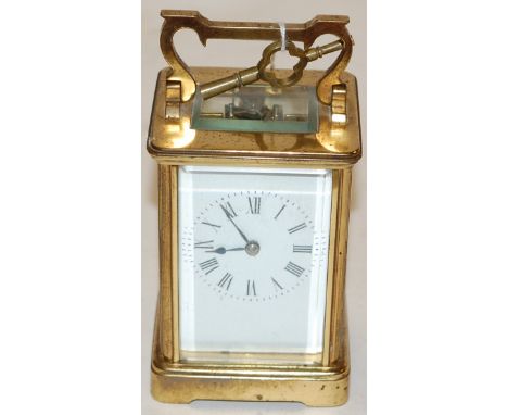 An early 20th century lacquered brass cased carriage clock having an enamel dial with Roman numerals, visible platform, lever