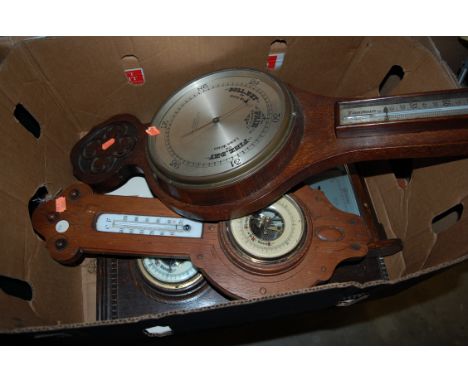 An early 20th century carved oak barometer together with three other oak cased barometers (4)