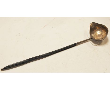 A 19th century white metal and coin inset toddy ladle on a spirally turned whalebone handle