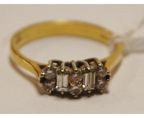 A ladies 18ct gold diamond dress ring, arranged as three pairs of small brilliants flanked by a single baguette, size K   Con