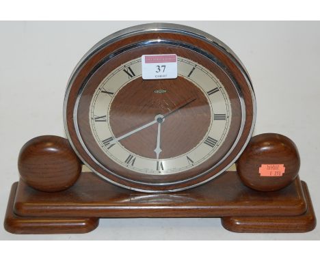 An Art Deco oak cased and chrome mantel clock, having silvered chapter ring with Roman numerals    Condition Report / Extra I