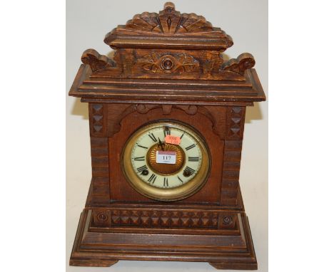A late 19th century oak cased mantel clock by the Ansonia Clock company of New York, having enamelled chapter ring with Roman
