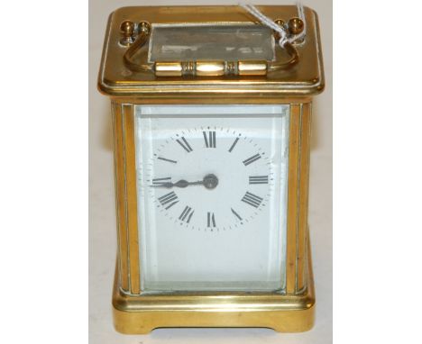 An early 20th century lacquered brass cased carriage clock having an enamelled dial with Roman numerals and visible platform 