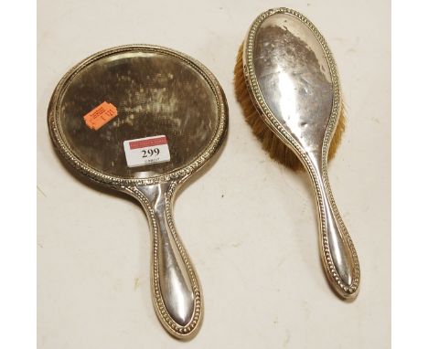 A George V silver backed hand mirror together with matching brush (2)