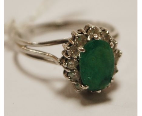 A ladies 14ct white gold, emerald and diamond set cluster ring, size M/N