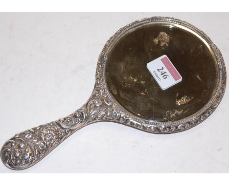An Edwardian silver backed hand mirror with scrolling repoussee decoration   Condition Report / Extra Information  Splits to 