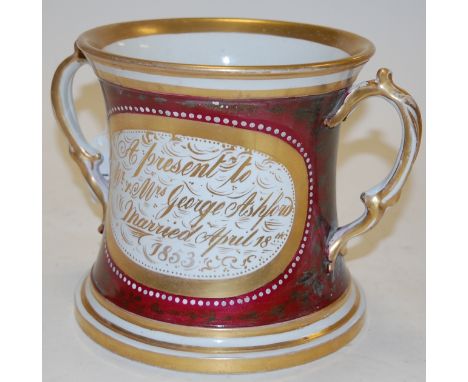 A 19th century loving cup, the central panel depicting a mountain lake scene with opposing presentation inscription, on a dee