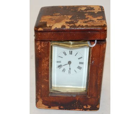An early 20th century lacquered brass cased carriage clock of shaped rectangular form having an enamel dial with Roman numera