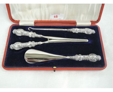 A cased Edwardian silver handled 3 piece dressing set comprising button hook, glove stretcher and shoe horn, Birmingham 1907,