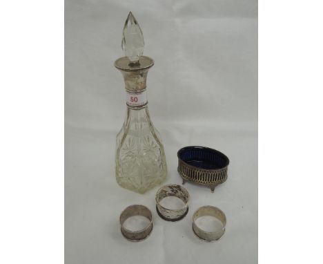 A small cut glass decanter of hexagonal form with silver collar, London 1920, Wolfsky & Co Ltd, three HM silver napkin rings 