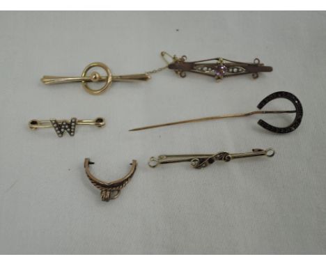 Four yellow metal bar brooches including 9ct, a horse shoe stick pin etc, approx 11g