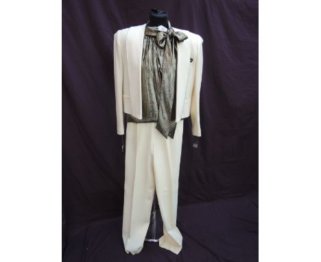 A lady's cream wool suit by Nolan Miller Dynasty Collection having short fitted edge to edge jacket, matching trousers and go