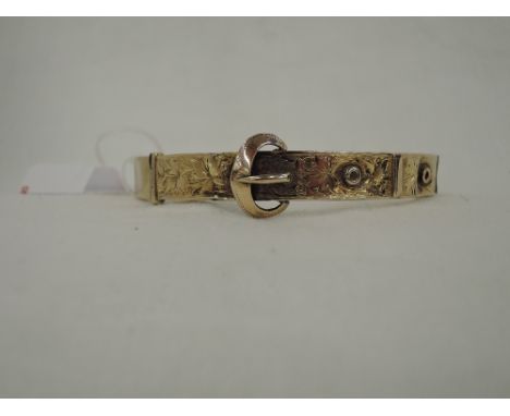 A 9ct gold hinged bangle modelled as a belt having engraved foliate decoration, Chester 1920,  approx 9.3g