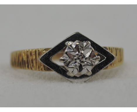 A lady's dress ring having a diamond chip solitaire in an illusionary setting with an open diamond surround to bark effect sh