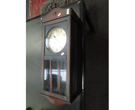 An early 20th century oak frame wall clock having circular silvered dial and glass panel trunk