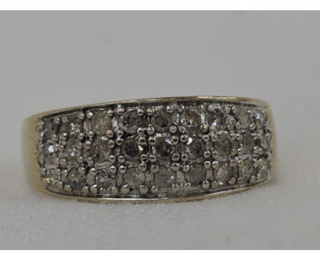 A lady's 9ct gold band ring having a triple row of diamond chips in a pave setting, approx .25ct,  size R